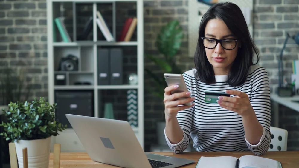 Pessoa realizando pagamento pelo celular, imagem editorial sobre compra pela internet e direito do consumidor
