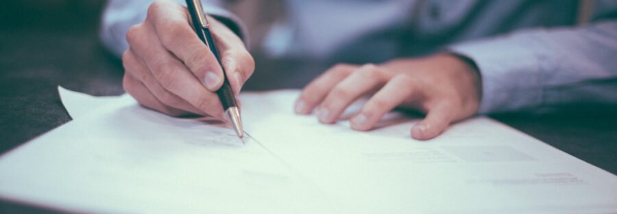 Documentos contratuais e caneta em mesa de trabalho