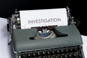 Máquina de escrever e documentos em composição editorial sobre inquérito policial, investigação e provas